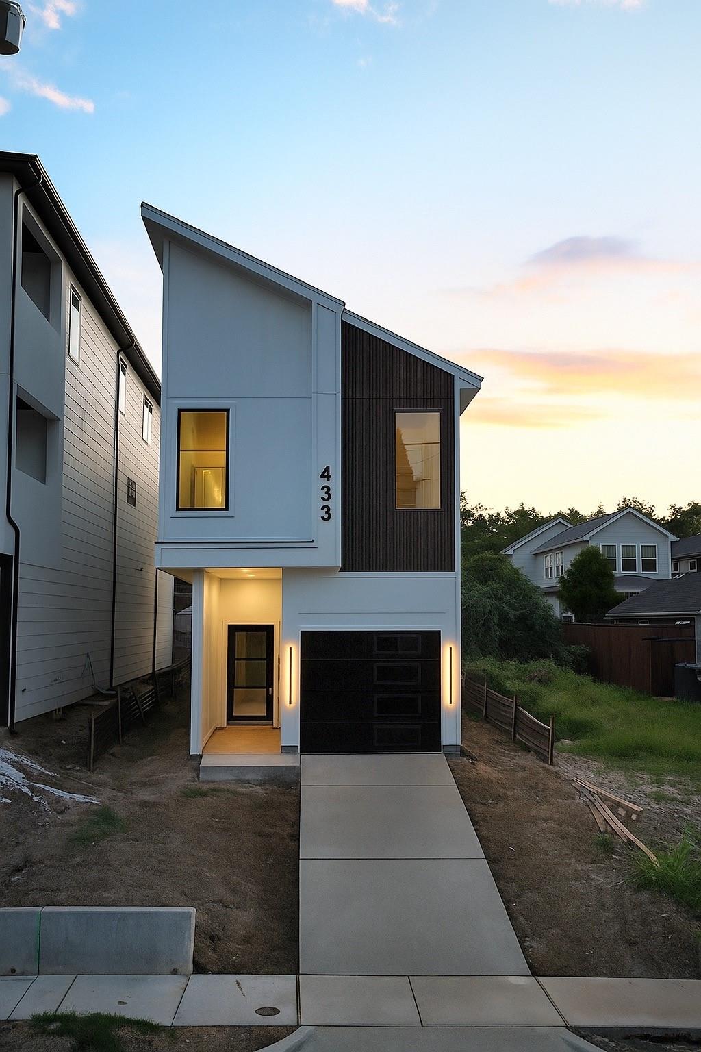 Contemporary residential building exterior at dusk, concrete and glass architecture, deep blue sky, architectural photography